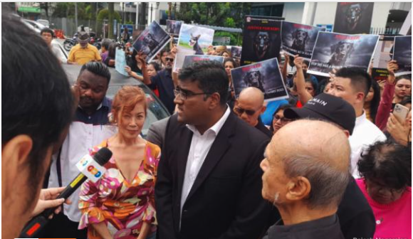 Rajesh Nagarajan speaking to the press with a bunch of people aorund him